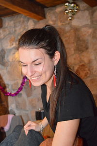 Smiling young woman sitting at home