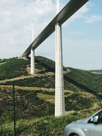 Road by bridge against sky