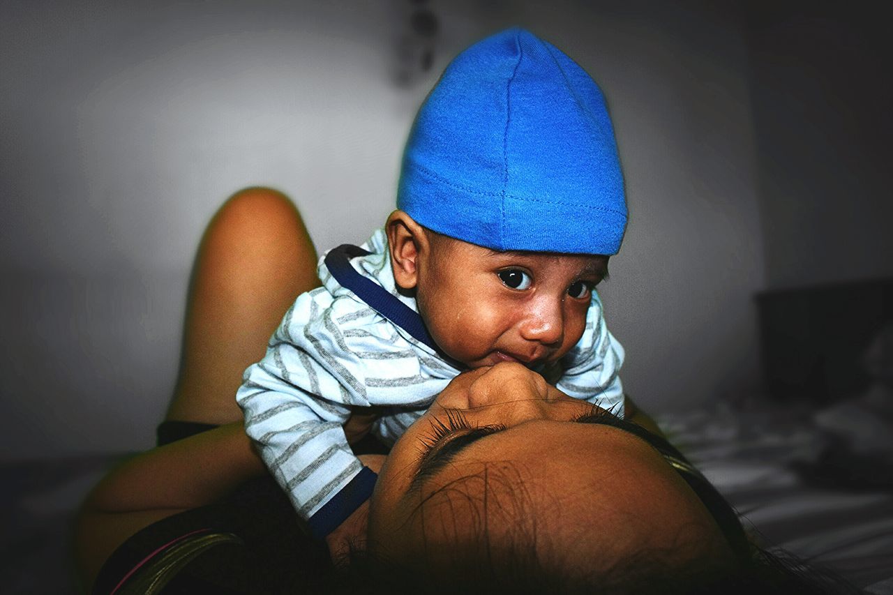 indoors, lifestyles, casual clothing, portrait, blue, leisure activity, person, looking at camera, home interior, young men, front view, men, headshot, close-up, relaxation, one animal, focus on foreground, bed