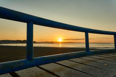 Bridge over sea against sky during sunset