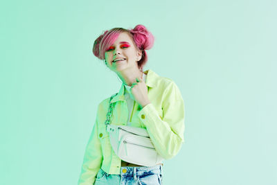 Portrait of young woman standing against white background