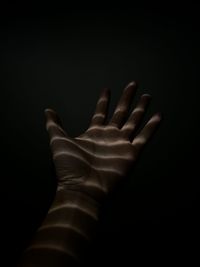 Close-up of human hand against black background