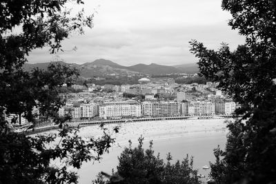 Cityscape by sea against sky