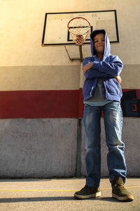 Low angle portrait of boy standing on basketball court