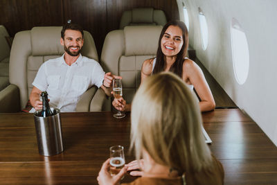 Colleagues enjoying alcohol in airplane