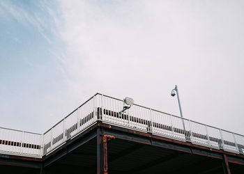 Low angle view of bird perching on bridge against sky