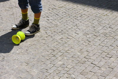 Low section of man standing on cobblestone