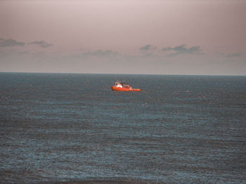 Scenic view of boat in sea against sky during sunset