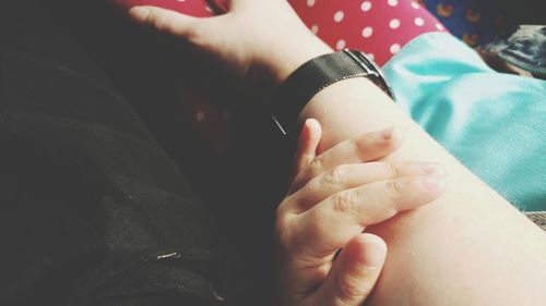 Low section of man holding baby hand