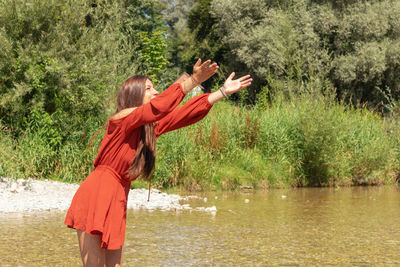 Side view of woman standing by lake