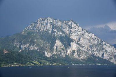 Scenic view of sea and mountains against sky