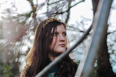 Girl looking away by plants in forest