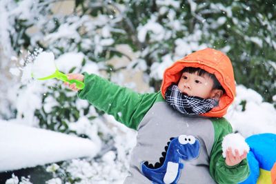 Close-up of cute boy in warm clothing playing outdoors