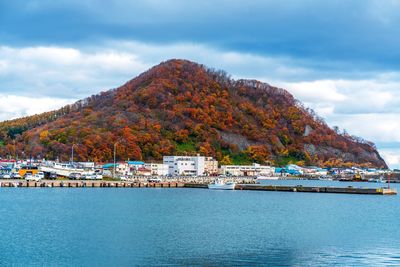 Scenic view of sea by buildings against sky
