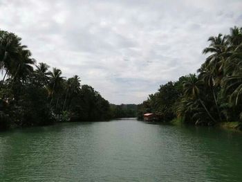 Scenic view of river against cloudy sky