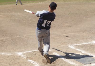 Rear view of man playing baseball