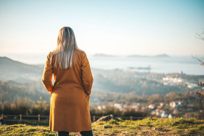 Rear view of woman standing against sky