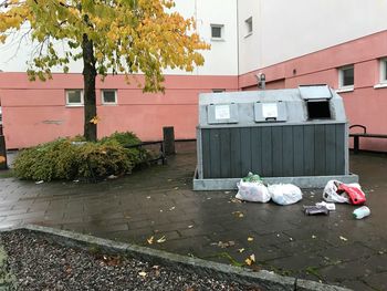 Garbage can against built structure