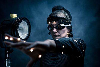 Woman wearing costume against black background