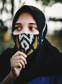 Close-up portrait of young woman covering face