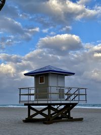 Lifeguard hut on beach against sky