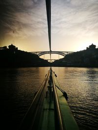 Bridge over river against sky during sunset