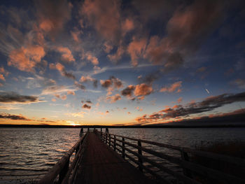 Pier over sea against sky during sunset