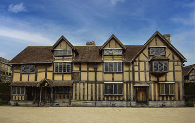 Houses by buildings against sky