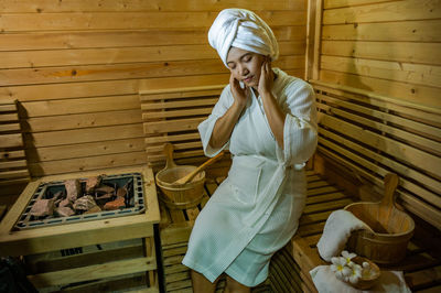 Woman hair wrapped in towel while sitting at spa
