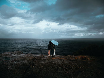 Man standing on sea during sunset