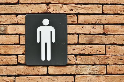 Close-up of sign on brick wall