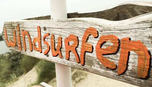 Close-up of information sign against clear sky at beach