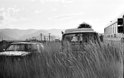 Abandoned vehicle on field against sky