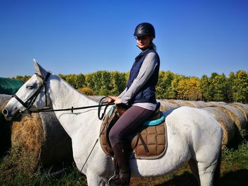 Side view of woman sitting on horse