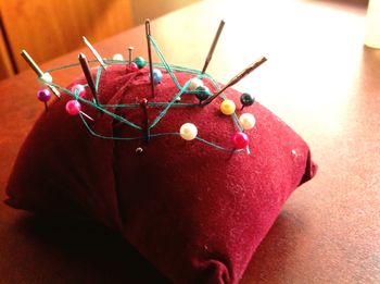 Close-up of straight pins in pillow on table