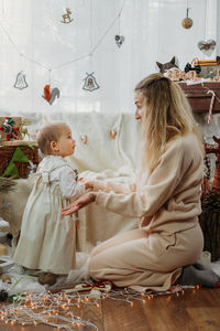 Smiling mother with daughter amidst decoration at home