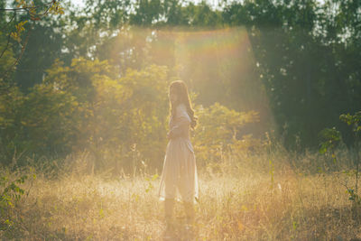 Side view of woman standing on field