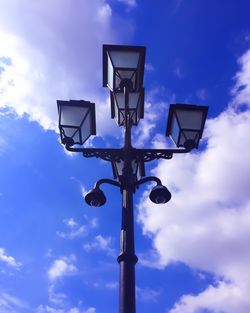 Low angle view of lamp post against cloudy sky