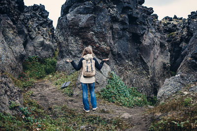 Rear view of woman standing on rock