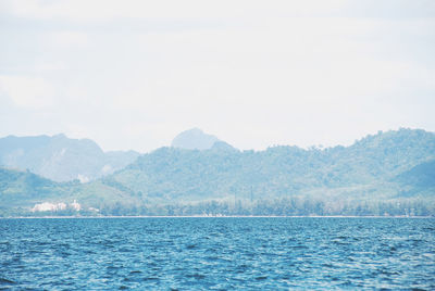 Scenic view of sea and mountains against sky