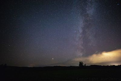 Scenic view of silhouette landscape against star field