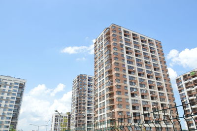 Low angle view of modern buildings against blue sky