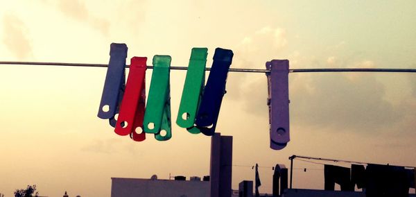 Low angle view of multi colored flags hanging against sky