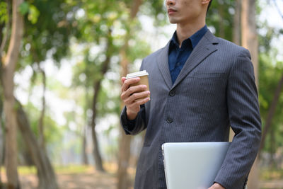 Midsection of businessman using mobile phone