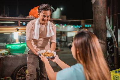 Portrait of young woman preparing food at restaurant