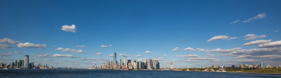 City at waterfront against cloudy sky