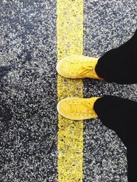 Low section of man standing on road