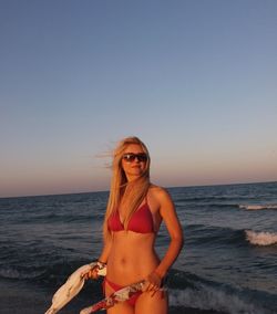 Portrait of woman at beach against sky