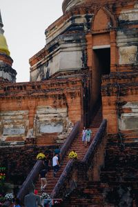 Low angle view of people at temple against sky