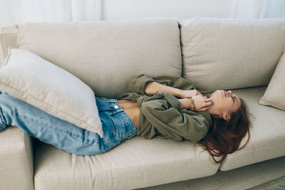 Side view of woman sleeping on bed at home